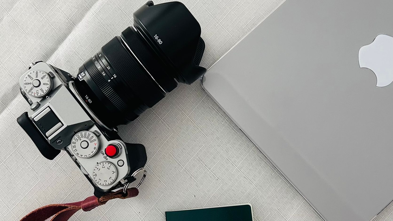 Passport, laptop, and camera arranged for international travel planning