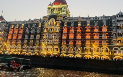 Illuminated Taj Mahal Palace hotel beside the waterfront in Mumbai at dusk