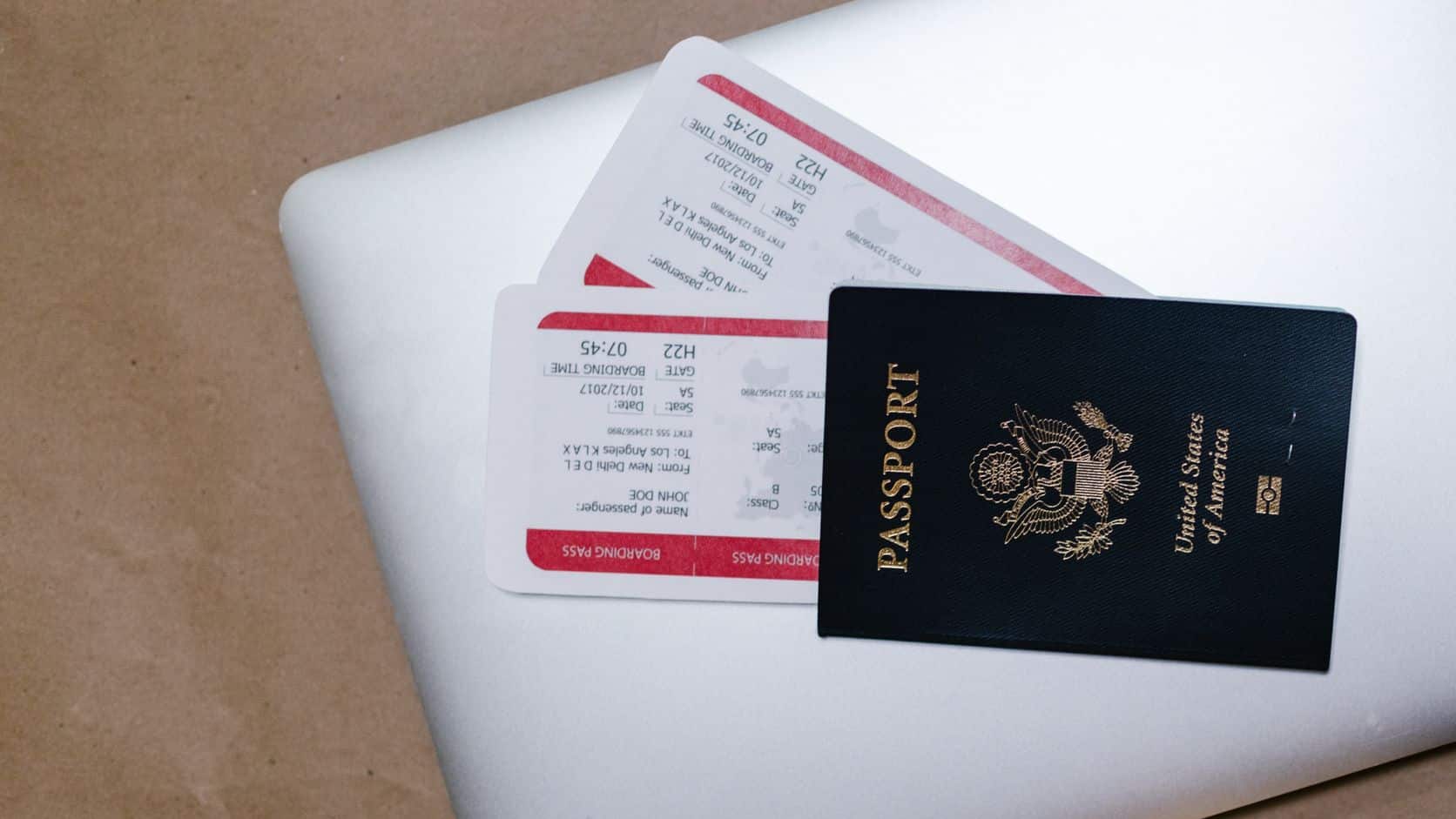 Passport and boarding passes arranged on a laptop