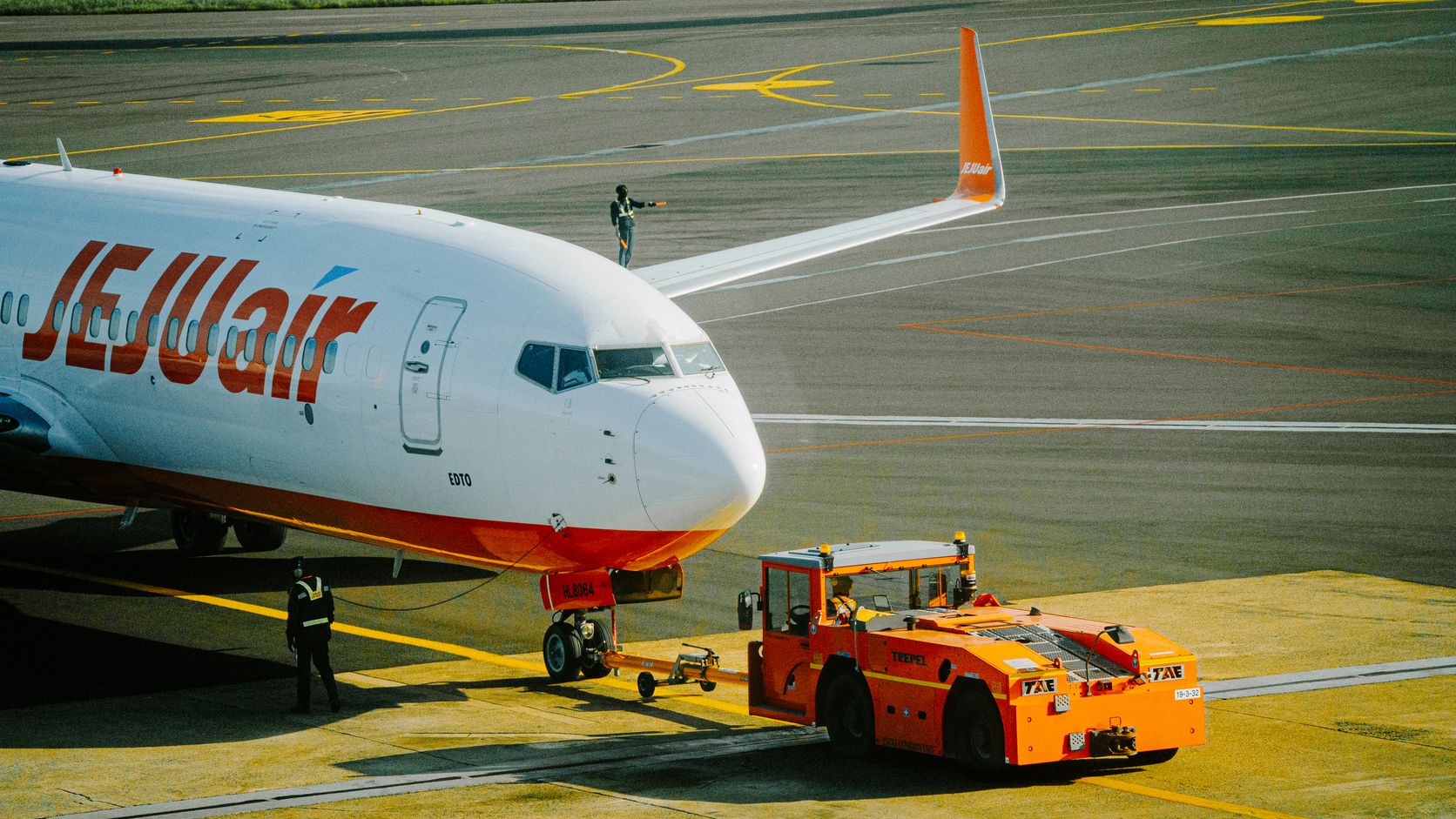 Commercial airplane being towed across an airport tarmac