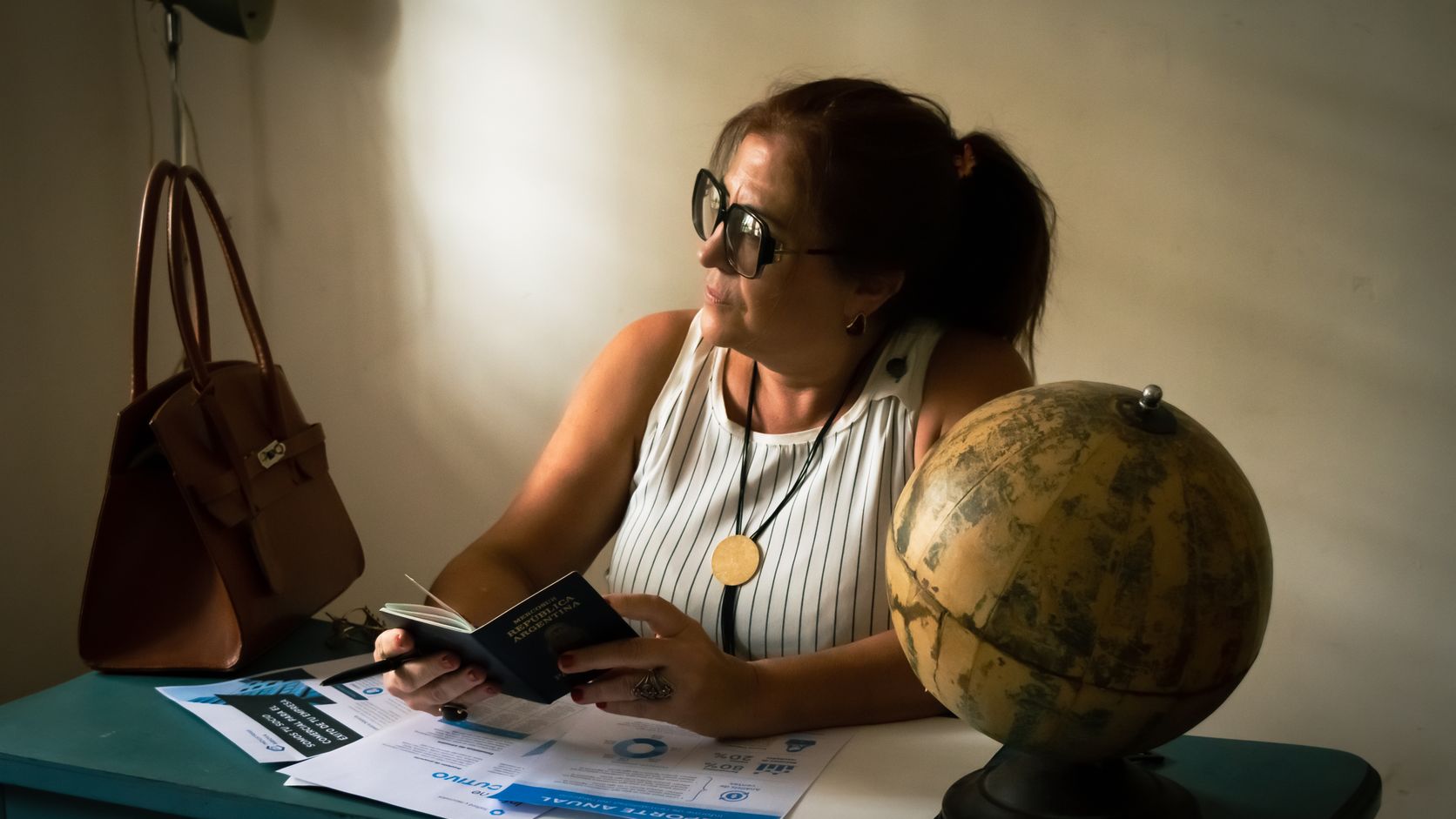 Traveler reviewing documents beside a globe